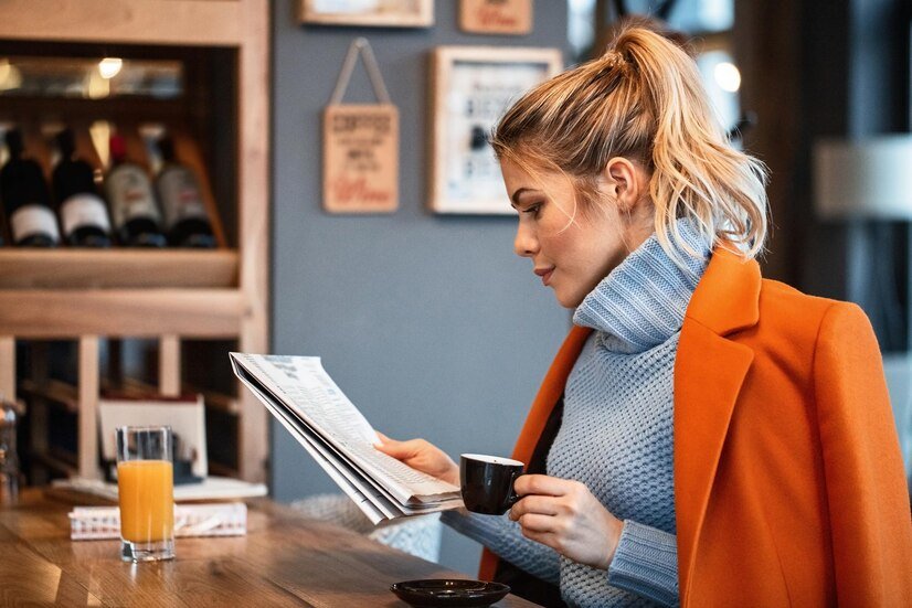 female-freelancer-relaxing-coffee-break-reading-newspaper-cafeteria_637285-280