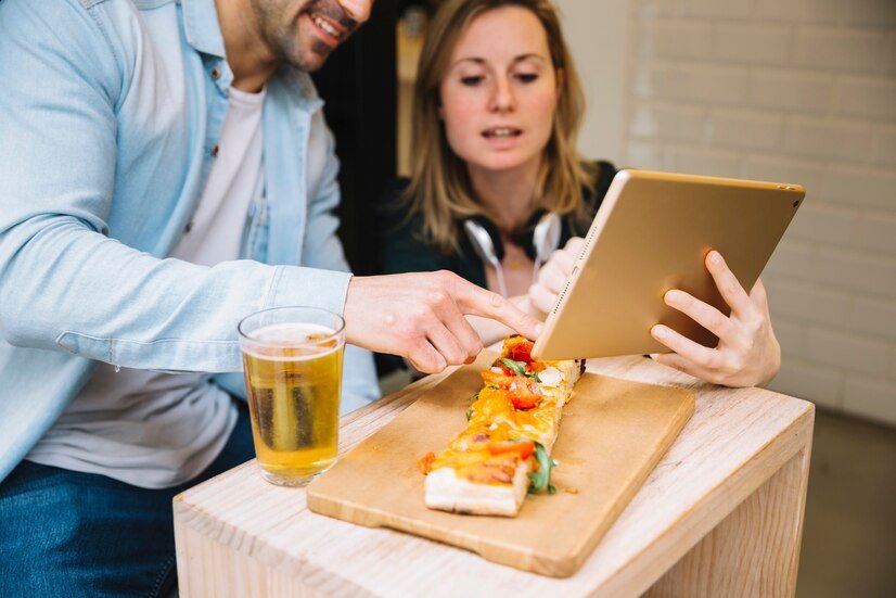 couple-watching-photos-tablet-cafe_23-2147826823