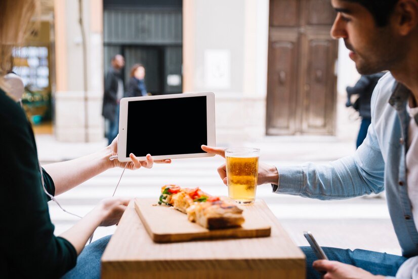 couple-using-tablet-sitting-restaurant